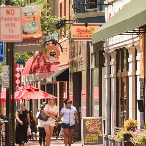 City sidewalk view of restaurants and shopfronts