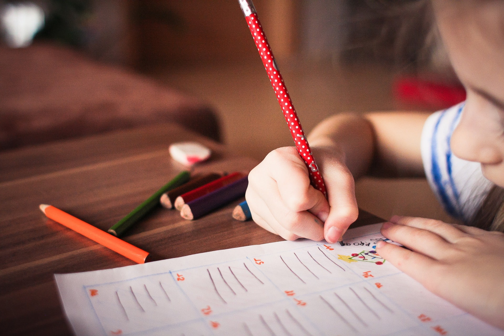 Young child doing school work on a desk.